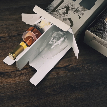 Prabangi dovanų dėžutė su SAULĖS MIDUS midaus buteliu ir stikline taure. Langeliai leidžia matyti graviruotą logotipą ir etiketę.